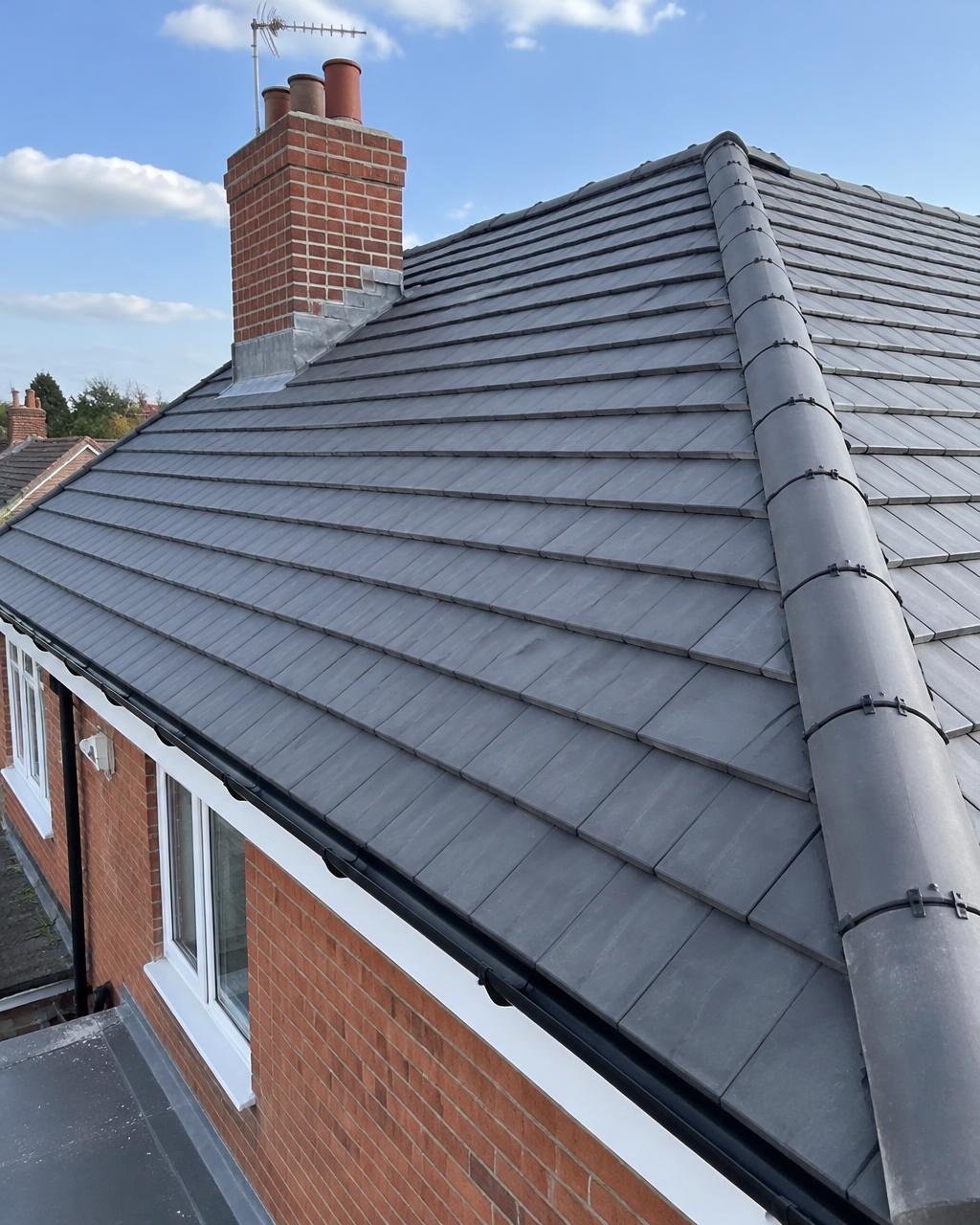 Roofers in Essex – Watts Curran Roofing Newly tiled pitched roof with lead flashing around the chimney